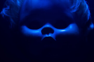 Creepy horror photo of a fashioned doll face close up with black background.