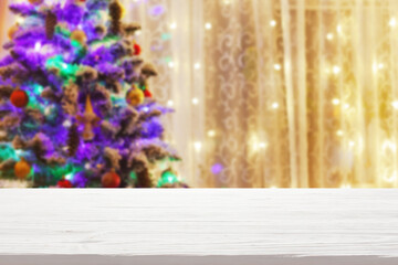 white wood table top on blur christmas tree with garland background