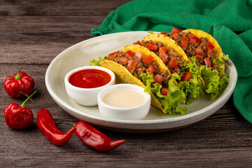 Mexican tacos with lettuce, beef and tomatoes.