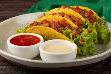 Mexican tacos with lettuce, beef and tomatoes.