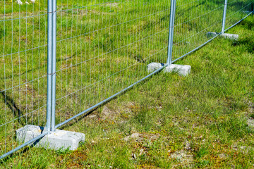 portable fence parts that are installed in concrete weight racks hold the stability of the fencing