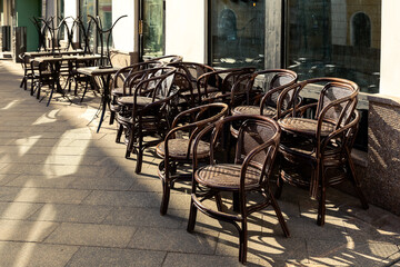 Wooden chairs on the pavement beside the cafe.