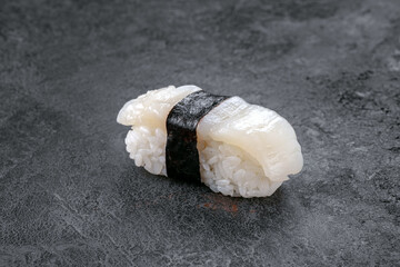 Scallop sushi nigiri on a stone background. Japanese traditional dish with fresh fish