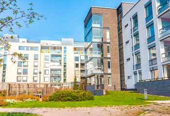 European residential complex of apartment buildings. Outdoor facilities. Eco-friendly living in a city. Modern block of flats. Scandinavian architecture. Green yard, trees, flowers. Helsinki, Finland