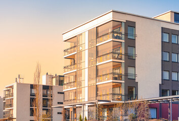 Modern luxury apartment building, block of flats with glass balconies in the sunset light. Real...