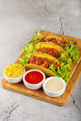 Mexican tacos with lettuce, beef and tomatoes.