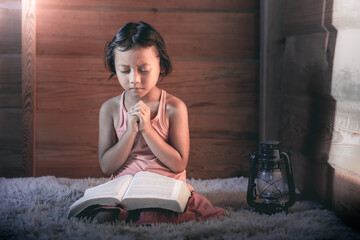 Little girl praying with Bible in morning, Prayer concept for faith.