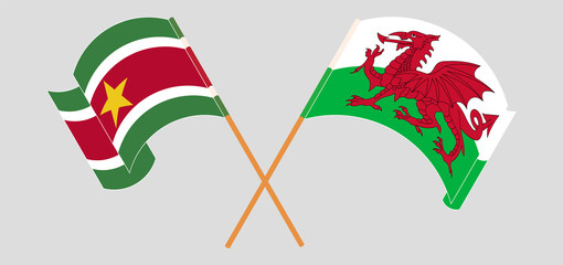 Crossed and waving flags of Suriname and Wales