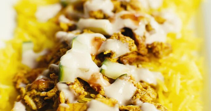 Macro probe shot of a freshly prepared chicken shawarma plate with yellow rice.