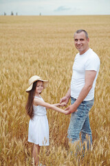 Naklejka na ściany i meble Dad and daughter have fun in the field . Happy family concept.