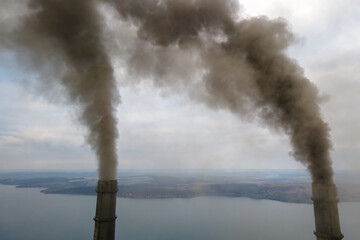 Naklejka na ściany i meble Aerial view of coal power plant high pipes with black smoke moving up polluting atmosphere.