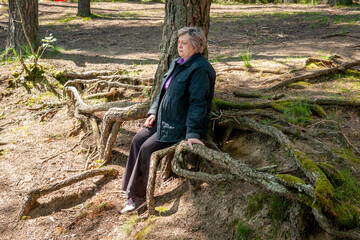  A sad mature woman is resting in the city park