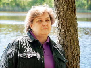 Cheerful mature woman is resting in the city park