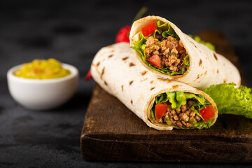 Mexican burritos stuffed with beef and salad.