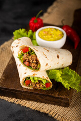 Mexican burritos stuffed with beef and salad.