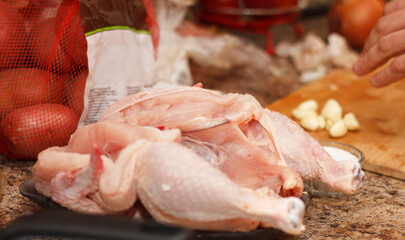 Cook man prepares chicken for baking with spices