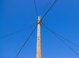 electric pole with wires against a blue sky