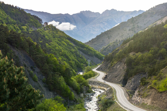 Asphalt road along the river. Valley in the Caucasus Mountains. Serpentine road in Ingushetia, Russian Federation. A beautiful highway among the peaks