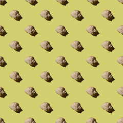 Seamless pattern with seashells on a yellow background under harsh lighting. Summer concept.