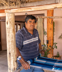 textile hispanic weaver craftsman making products on a wooden handicraft loom - latinx portrait	