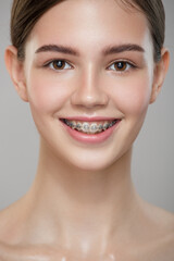 Close-up portrait cute smiling girl in braces. Gray background.