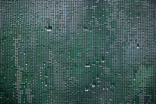 Water collected on window screen with green background