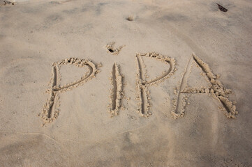 word in portuguese written on the beach sand