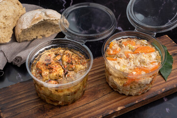 chicken and pickled aubergines in pots with very elegant knife and fork and homemade country bread on wooden board