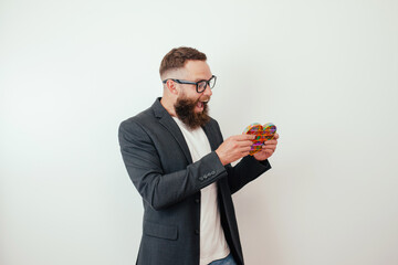 Stylish cheerful young hipster guy with beard plays with a popular toy pop it. Anti stress sensory fidget push pop toy. - obrazy, fototapety, plakaty