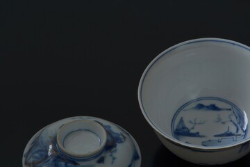 Lay out of picture rice bowl.  This is a very fine example of Japanese traditional antique “ imari ware ”.  black background・dim lighting soft focus image.