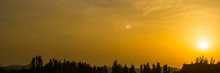 Fototapeta premium Landscape with dramatic light - beautiful golden sunset with saturated sky and clouds.