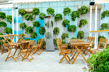 stylish cafe with decor of green living plants, wooden furniture, table and chairs without visitors. eco-friendly direction in public catering and restaurants. landscaping of restaurants