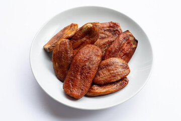 Sun dried bananas in white plate on white background.