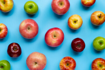 Ripe apples on blue background. Copy space