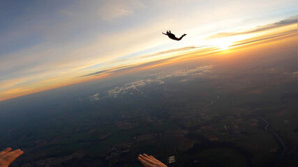 Silhouette of skydivers at sunrise - 438269134