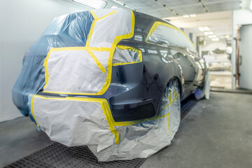 Auto Body shop with painted car inside a spray booth