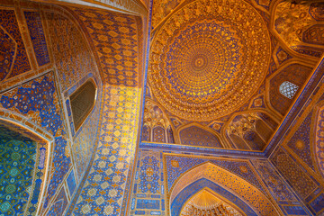 Fototapeta na wymiar Interior of Tilya Kori Mosque and Madrasah in Registan Square. Decoration of gold applied by the kyndal method. Samarkand, Uzbekistan.