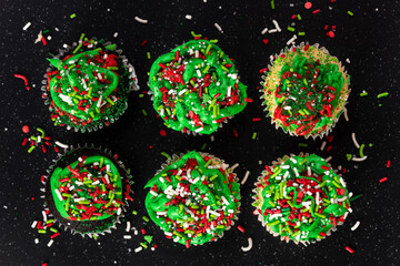 Sweet cup cakes with Christmas decoration on dark background.