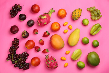 Many different delicious exotic fruits on pink background, flat lay