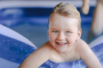 Little boy playing in vibrant blue backyard splash pool