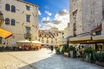 Tourists enjoy a sunny day as they eat at sidewalk cafes and window shop at the Fruit Square,...