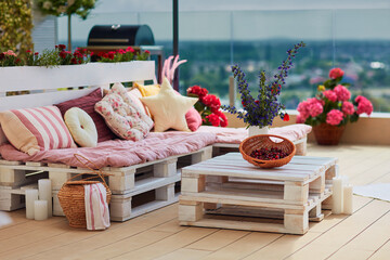 cute, cozy pallet furniture with colorful pillows at summer patio, lounge outdoor space - 438281514