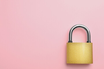 Modern padlock on pink background, top view. Space for text
