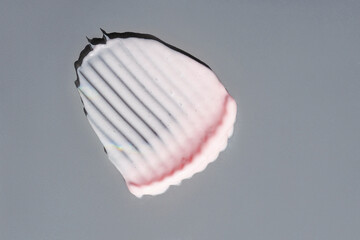 Pink cream texture on a grey background.