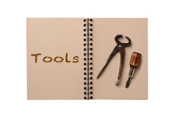 Two tools on the blank page of a notebook. The opposite page has the word Tools spelled out.