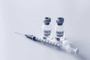 Vial of Covid-19 vaccine and 1 ml plastic syringe with needle isolated on the white background