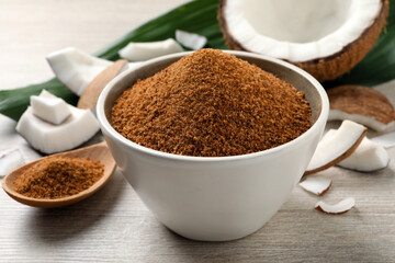 Natural coconut sugar in bowl on white wooden table