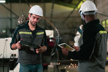 Two Industry engineers stand and discussion work in the factory workshop.