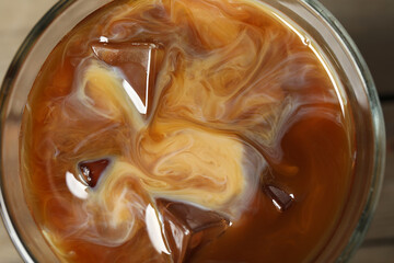Coffee with milk and ice cubes in glass, top view