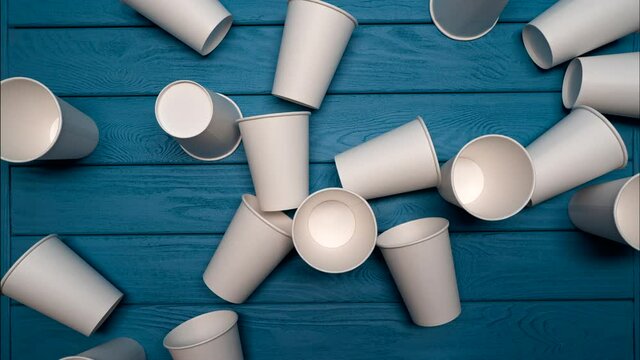 ZERO WASTE: Many paper cups on a blue table, Top view, Stop motion